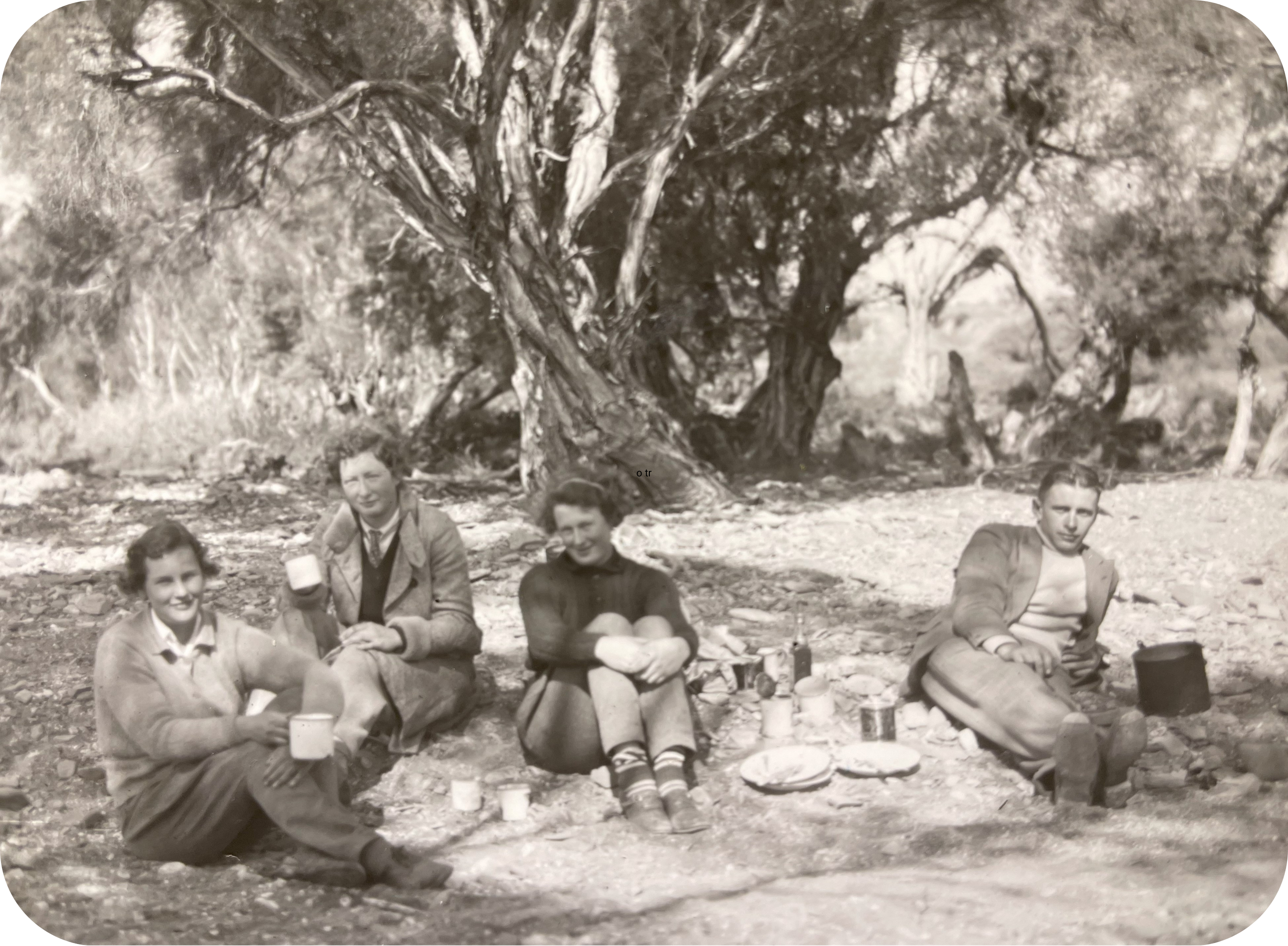 A group of four geology students pictured on a field trip in rural South Australia enjoying billy tea.