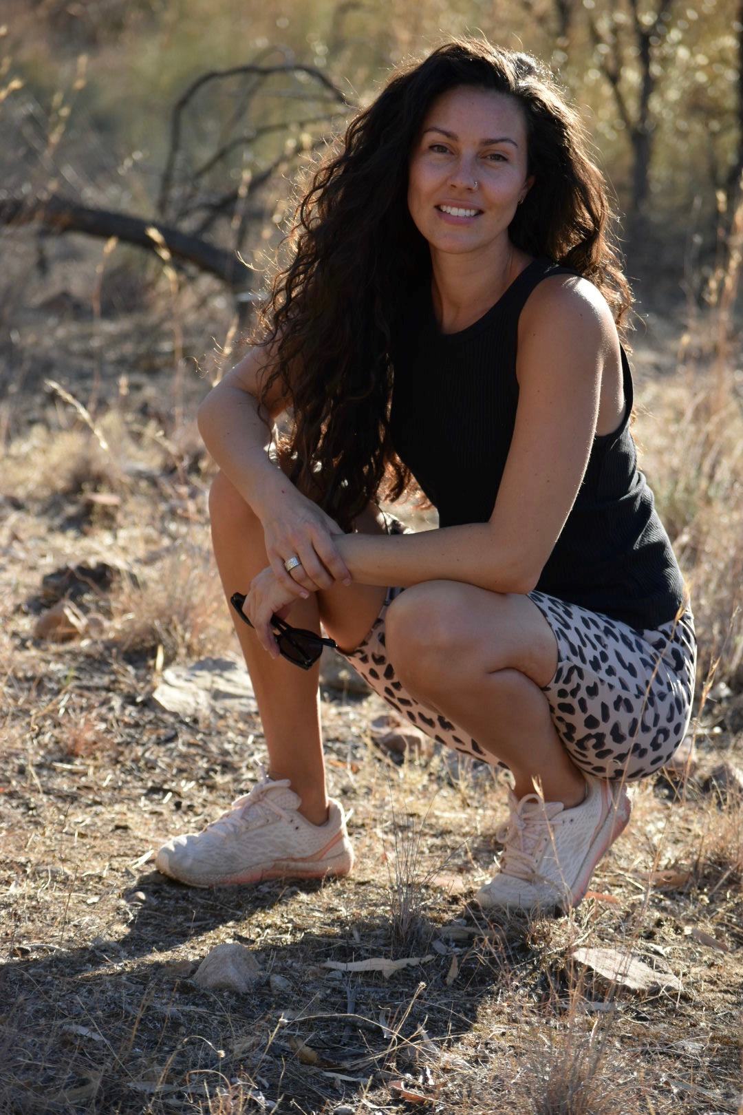 Image of Rebecca Gough, she is wearing a black top and leopard-print shorts.