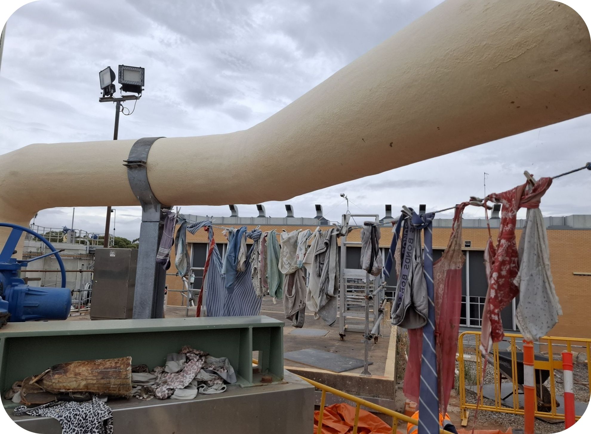 clothing items pulled from South Australian sewers pictured hanging on a rope under a large pipe