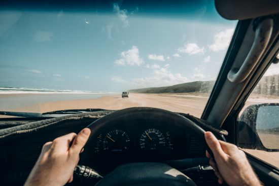Image of a person driving a car along one of SA's drive on beaches