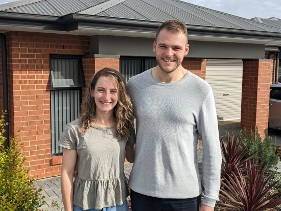 Image of a young women (Abigail) and young man (Blake) standing in front of their Dover Gardens home.