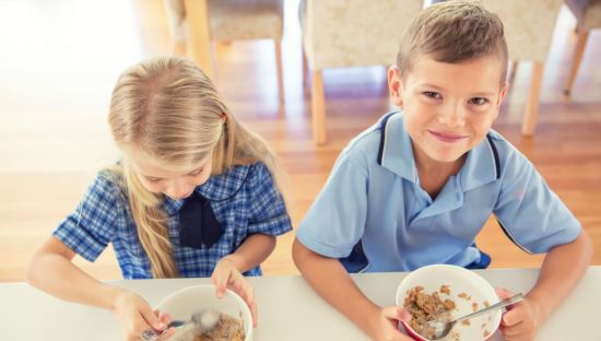 Image of two students eating breakfast at school