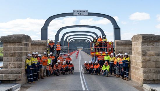 Workers from the Department of Infrastructure and Transport pose at the entrance of the refurbished Old Murray Bridge.