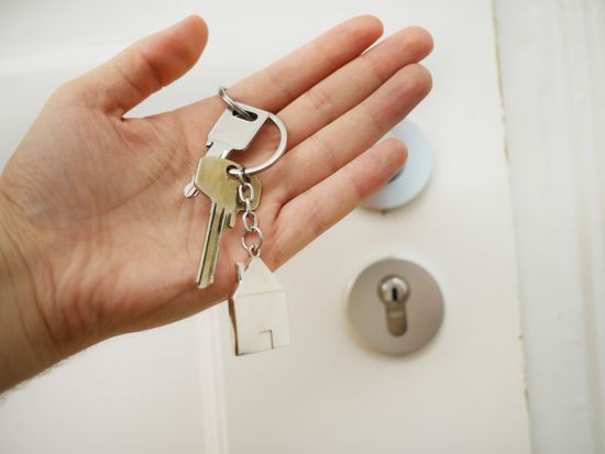 Image of a hand holding keys to a new home.