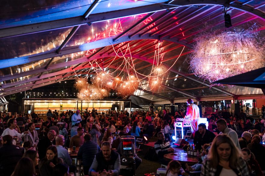 Image of a crowd of people under a marquee at night, at Tasting Australia's Town Square.