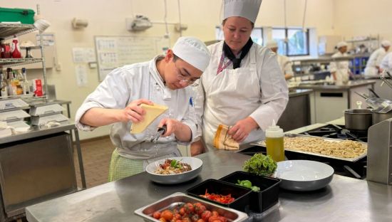 Image of Tafe SA cookery student and lecturer plating the ox-tail ragu pasta at TIROS restaurant 