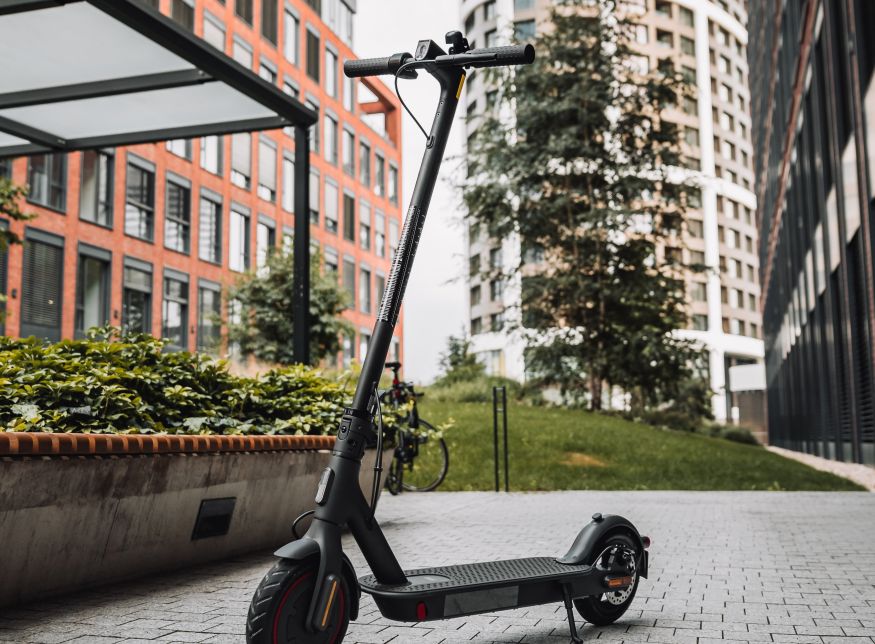 Image of a parked scooter on a city pathway.