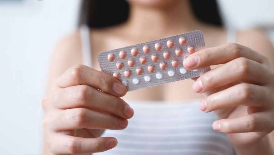 Image of a woman holding the resupply of the oral contraceptive pill.